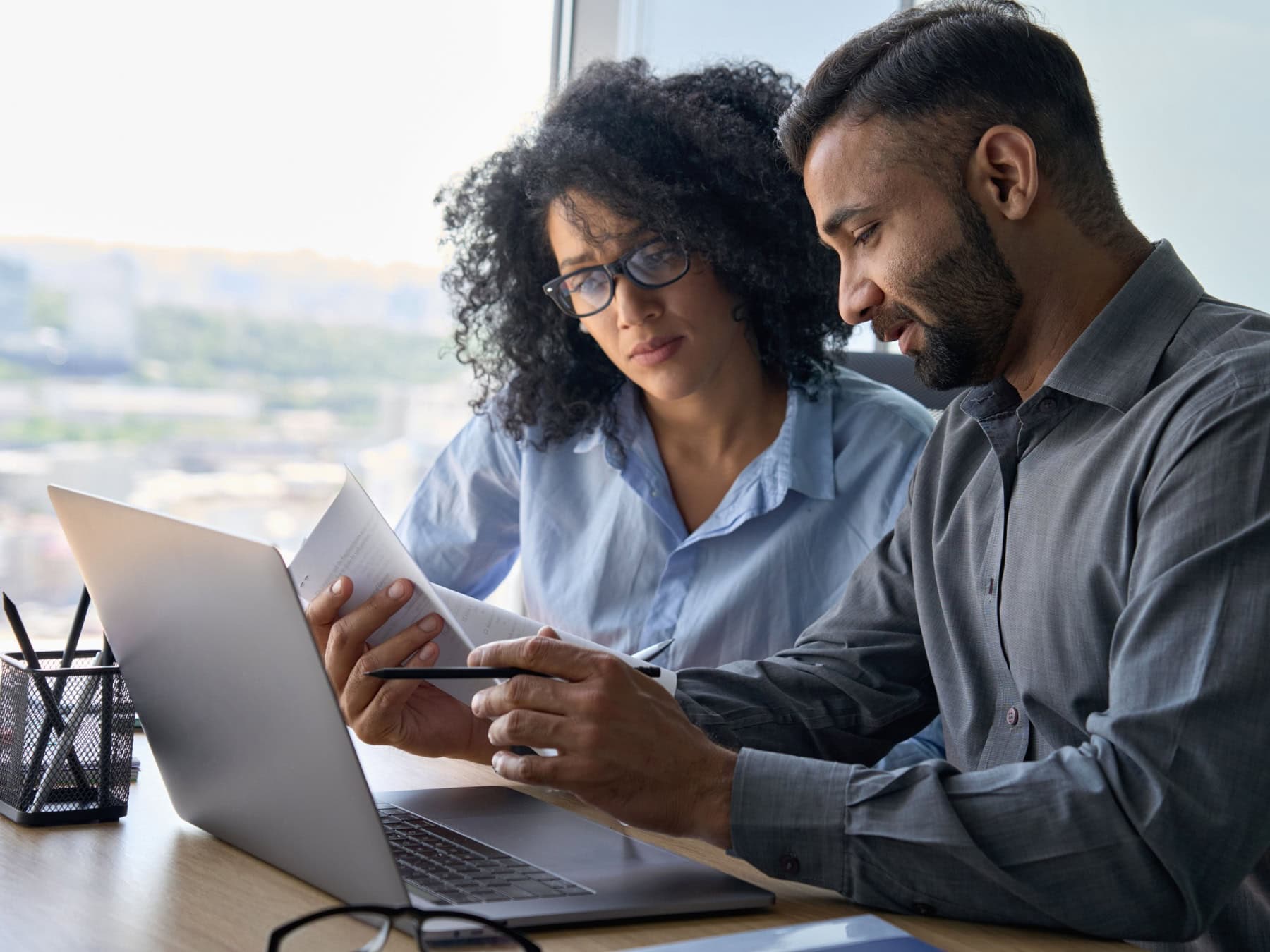 icf-about-diversity-inclusion-focus-areas A man and woman review information on a computer screen in a casual office.