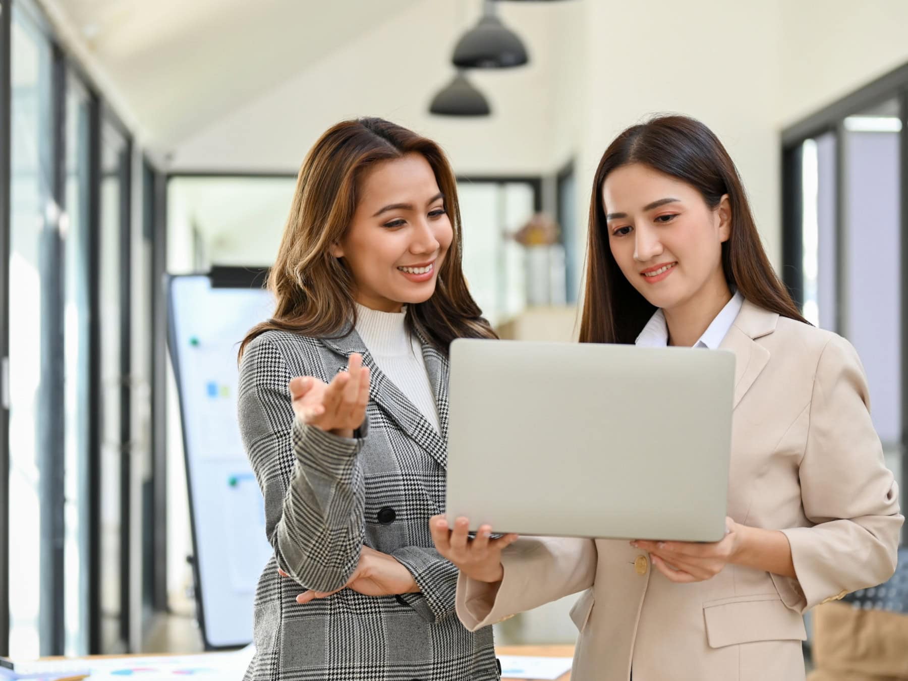 icf-about-join-organizational-membership Two woman look at the computer while in an office setting.