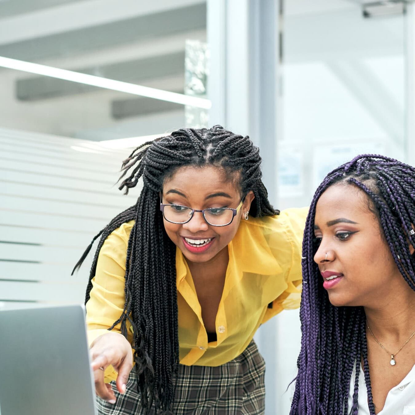 icf-about-pc-membership Two women look at a laptop in an office setting