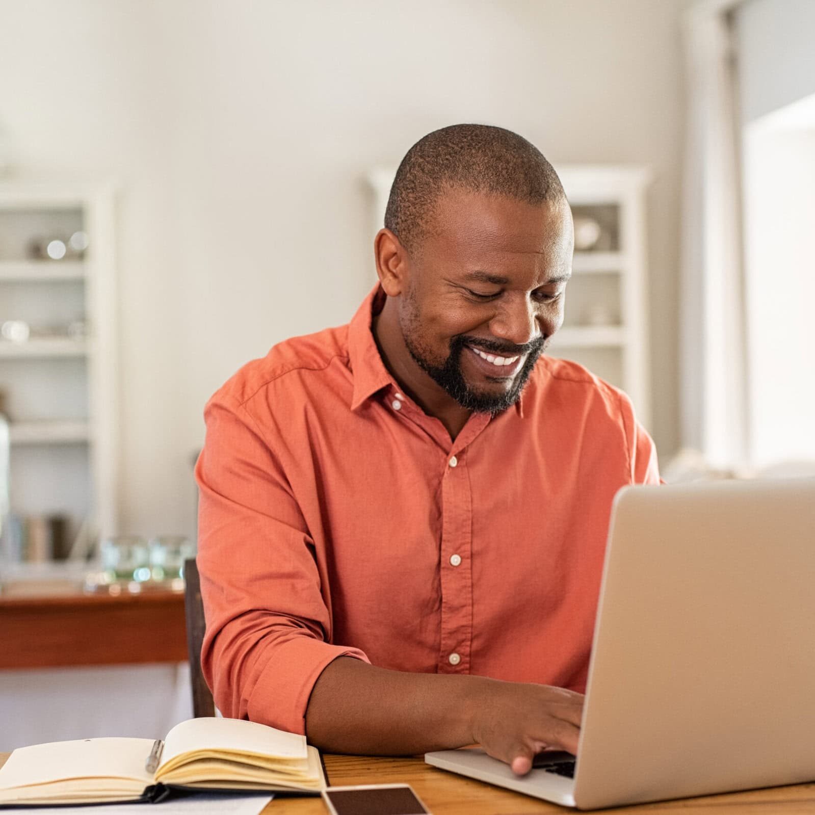 Happy mature black man using laptop Individual assessing their skills to become a successful professional coach