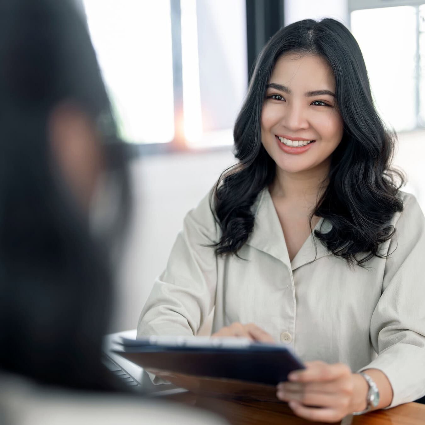 icf-about-social-responsbility A woman with a tablet is talking to another woman in an office setting