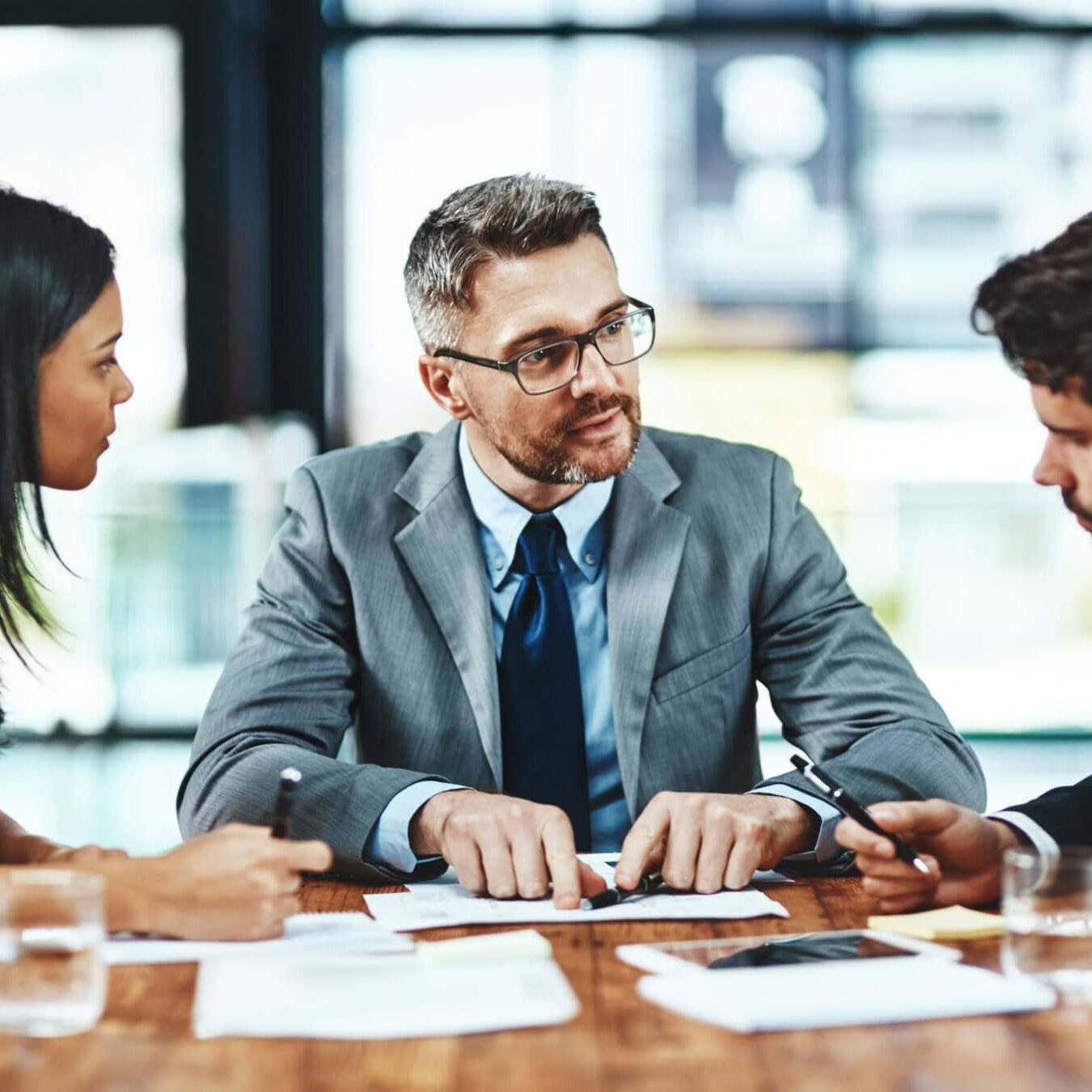 icf-about-strategic-alliance-join A group of professionals discuss Strategic Alliances in a group setting at a table.
