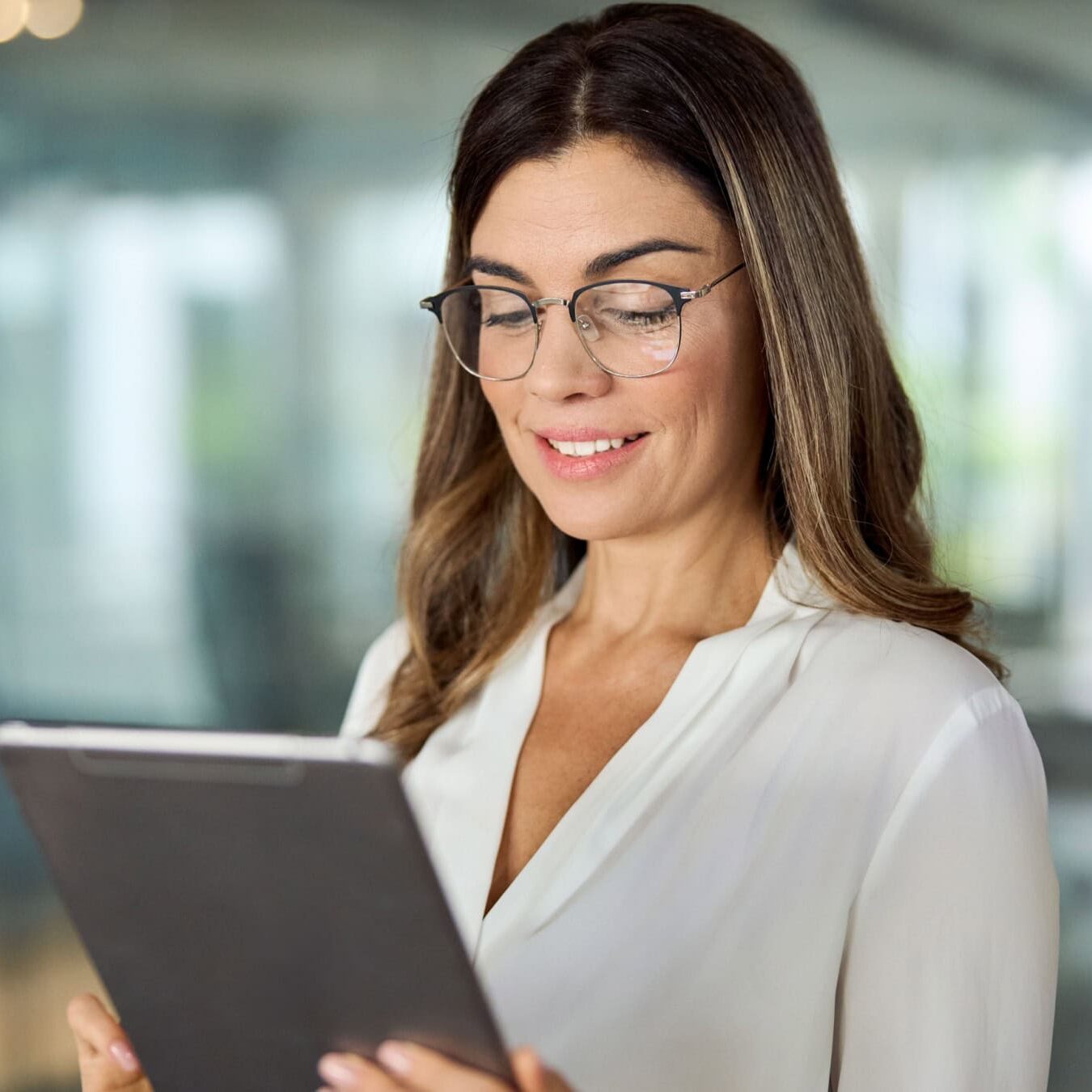 icf-about-strategic-alliances-potential A woman views her tablet in an office setting to find out more information about ICF Strategic Alliances.