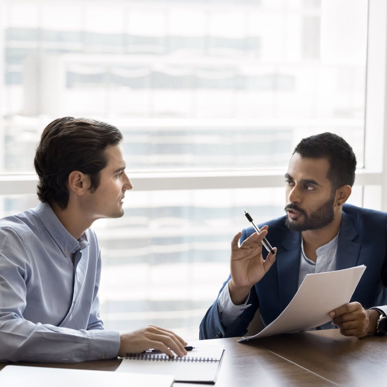 icf-advance-coaching-profession Two men are talking in an office setting on how to advance the coaching profession