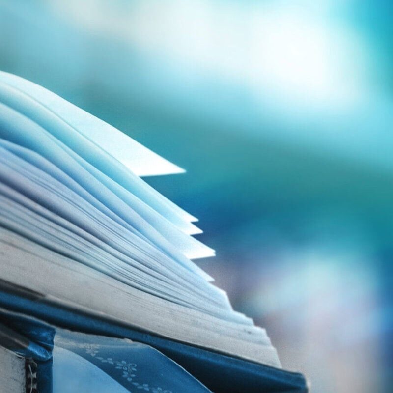 Book stack in the library and blurred bookshelf background for education. education background. back to school concept. Coach educators developing an ICF-accredited training program.