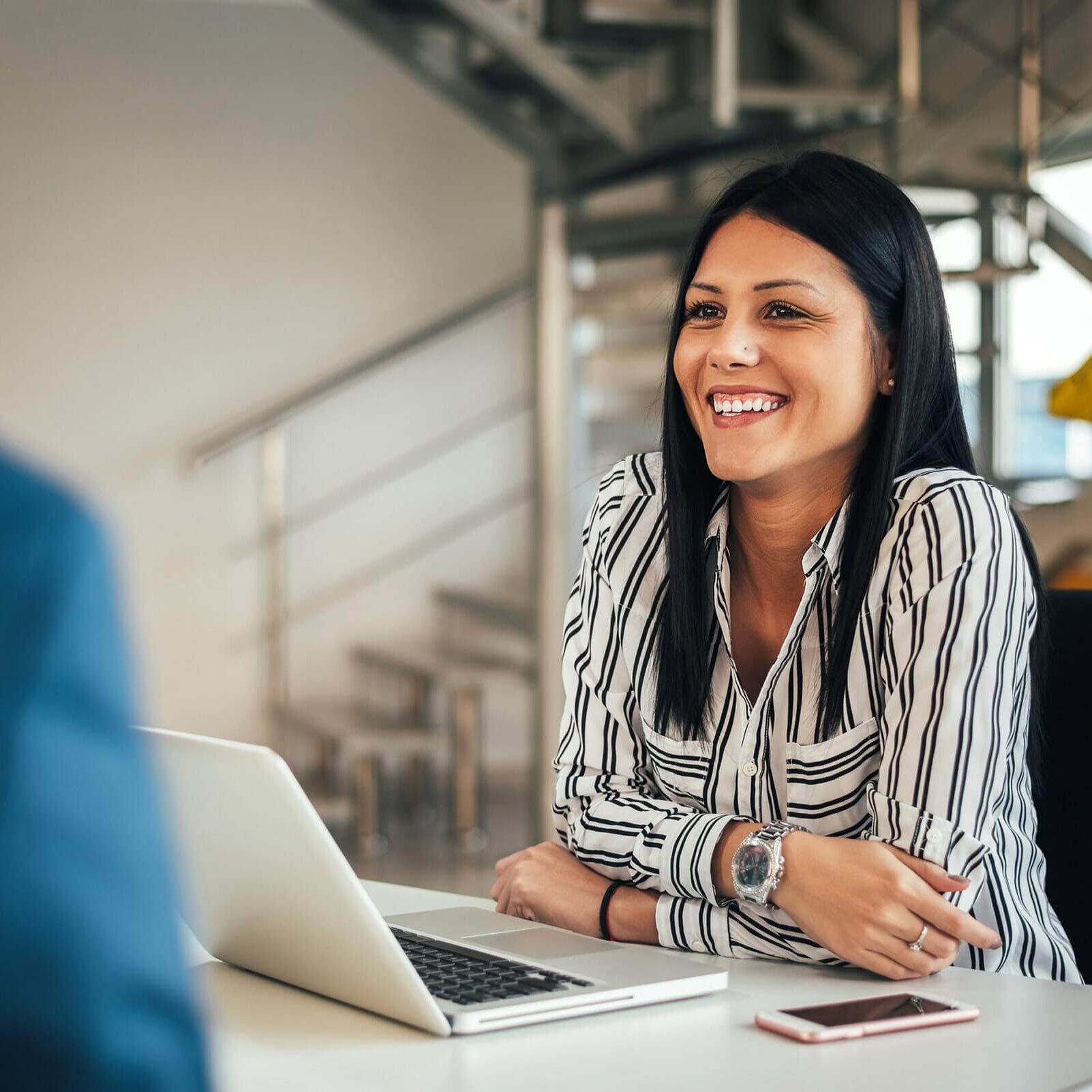Young smiling saleswoman talking with a client. Coach participating in ICF Engage to connect with peers