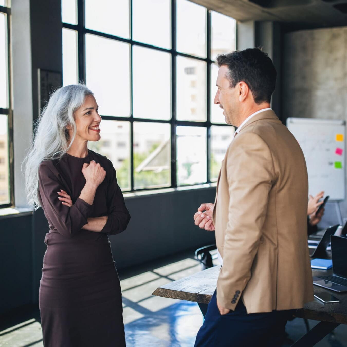 icf-credentialing-coaching-competencies A woman and a man discuss the ICF Coaching competencies in an office setting.