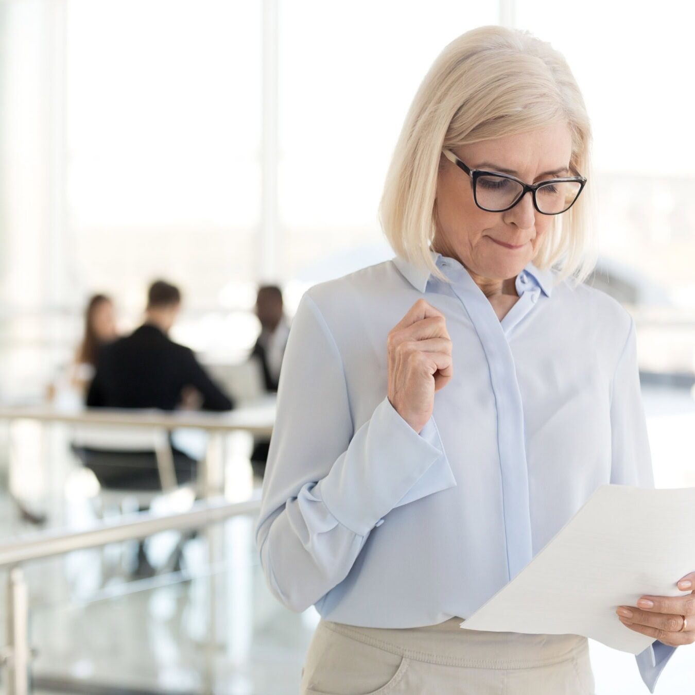 icf-credentialing-core-competencies A woman reading a document of the ICF Core Competencies in an office space