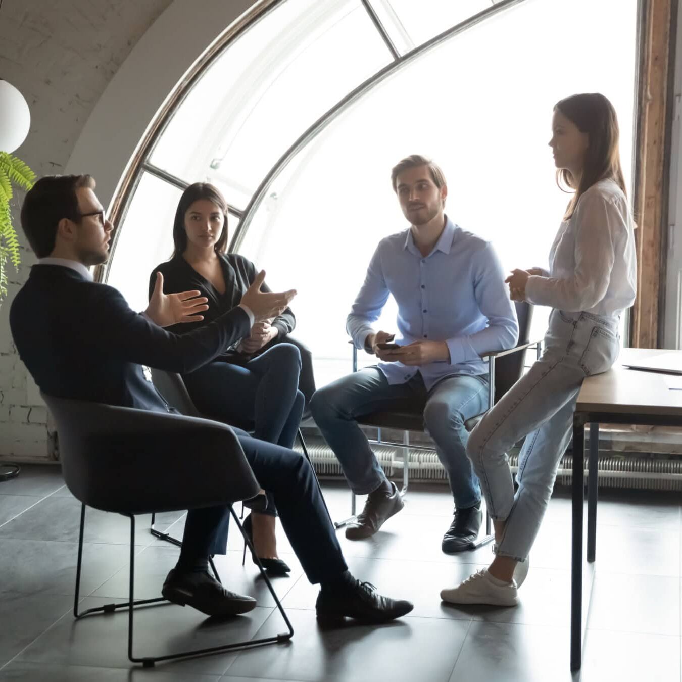 icf-credentialing-ethical-best-practices A group of people meet in a casual work environment to discuss coaching ethics.