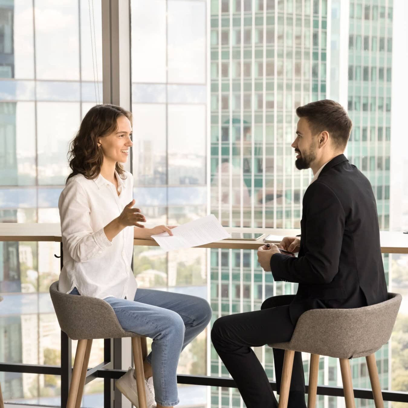 icf-credentialing-experience-requirements A man and a woman review the ICF credential experience requirements a table in a friendly conversation.