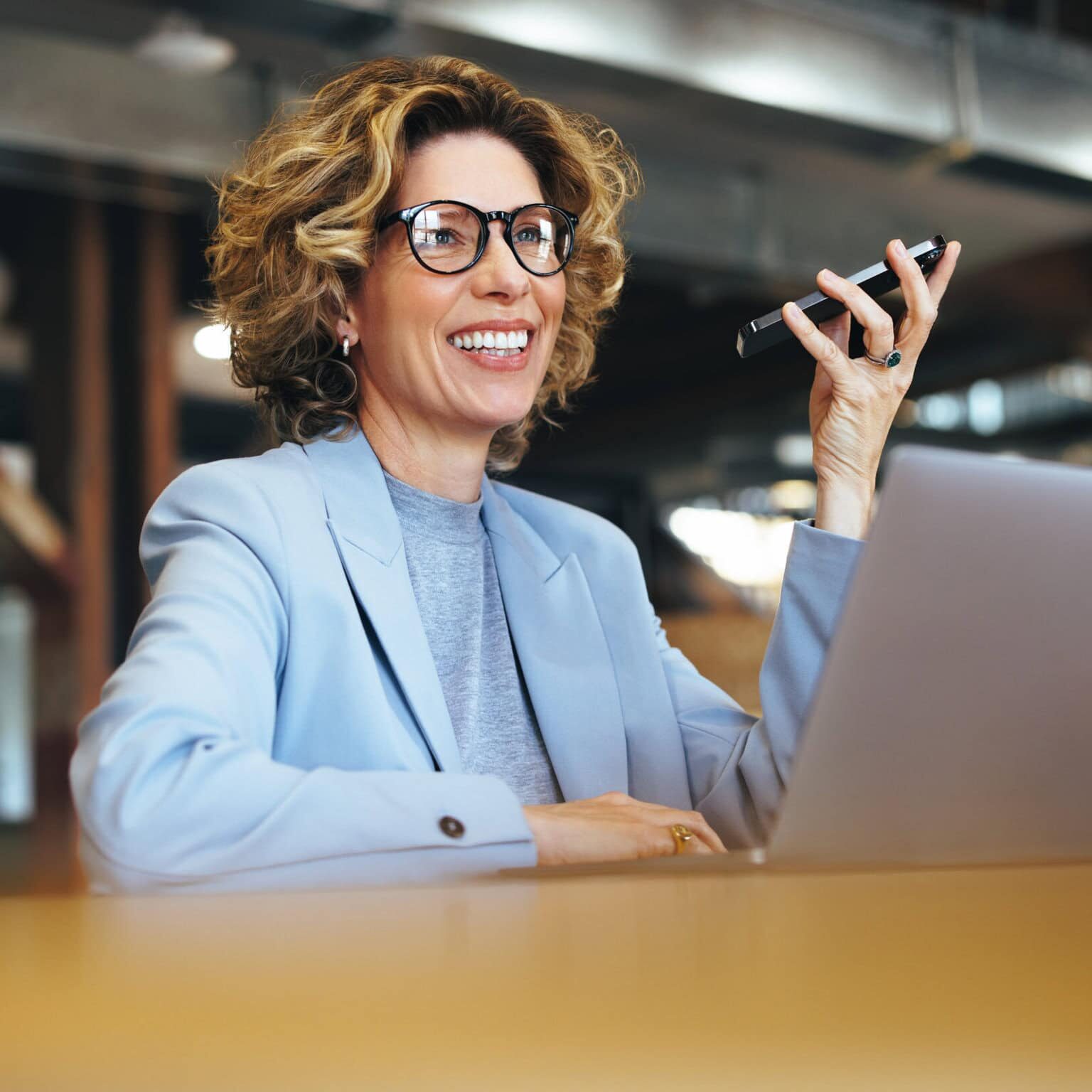 Engaged Coach Discussing Credentials and Standards Businesswoman smiling while on the phone discussing coach credentials and standards.
