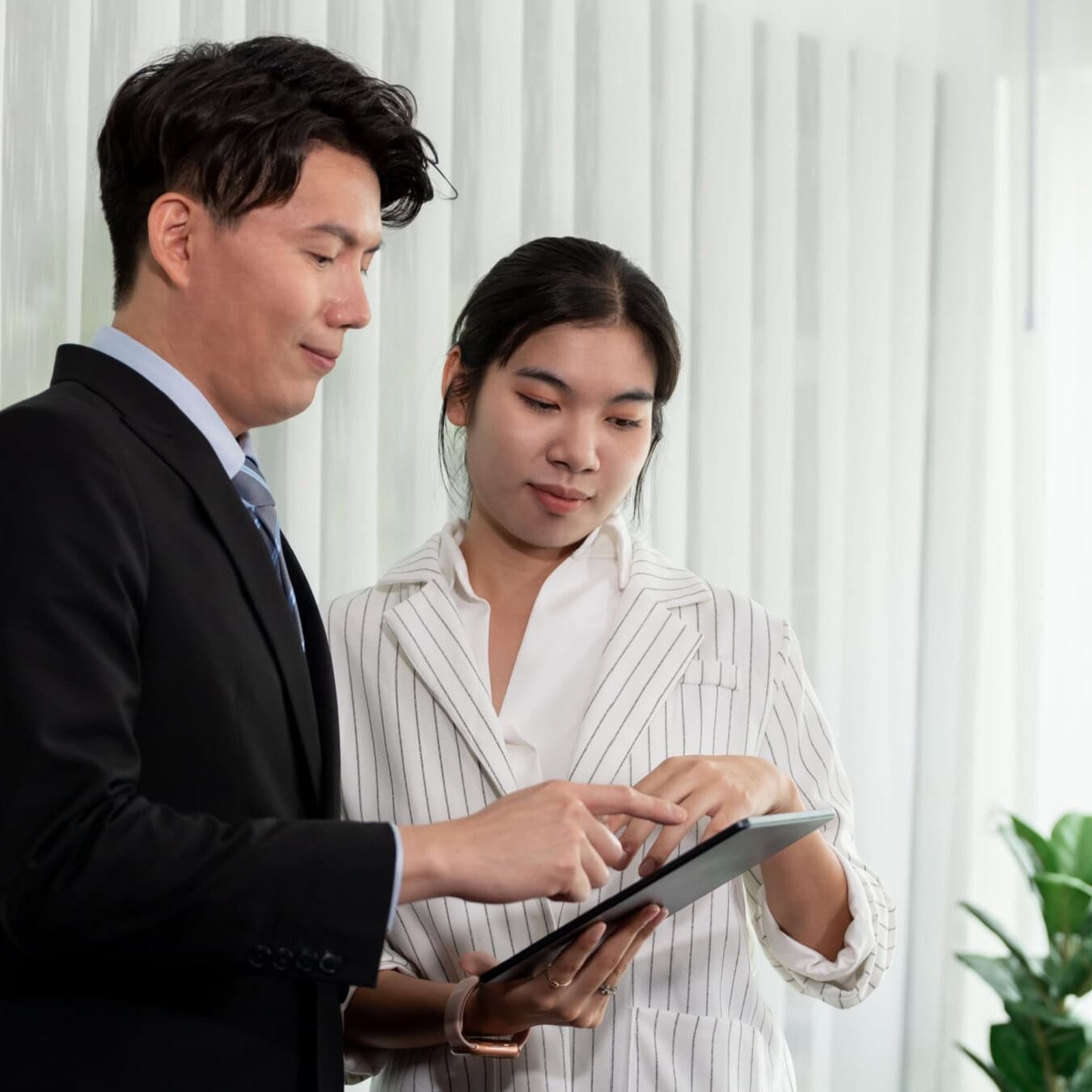 icf-credentials-and-certifications A man and woman work on an iPad in an office setting