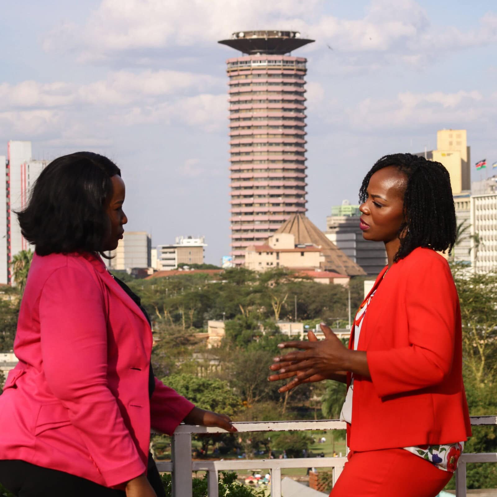 icf-get-coaching-empowering-business-growth Two professional women engaging in a coaching conversation on a rooftop with Nairobi's city skyline in the background, focusing on leadership development and business growth