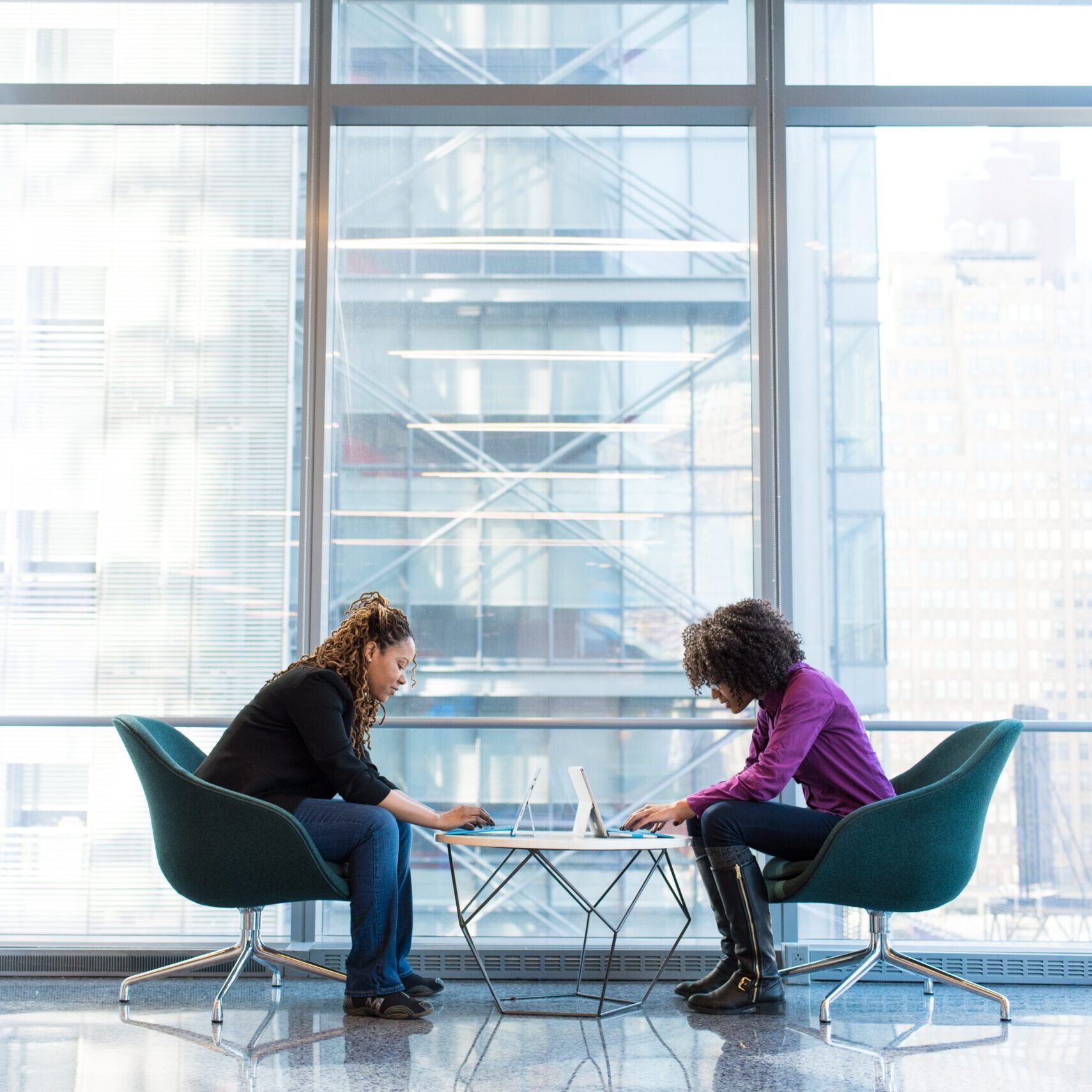 icf-professional-coaching-mentor-coaching-process Two women work together on their plan in a quiet office building