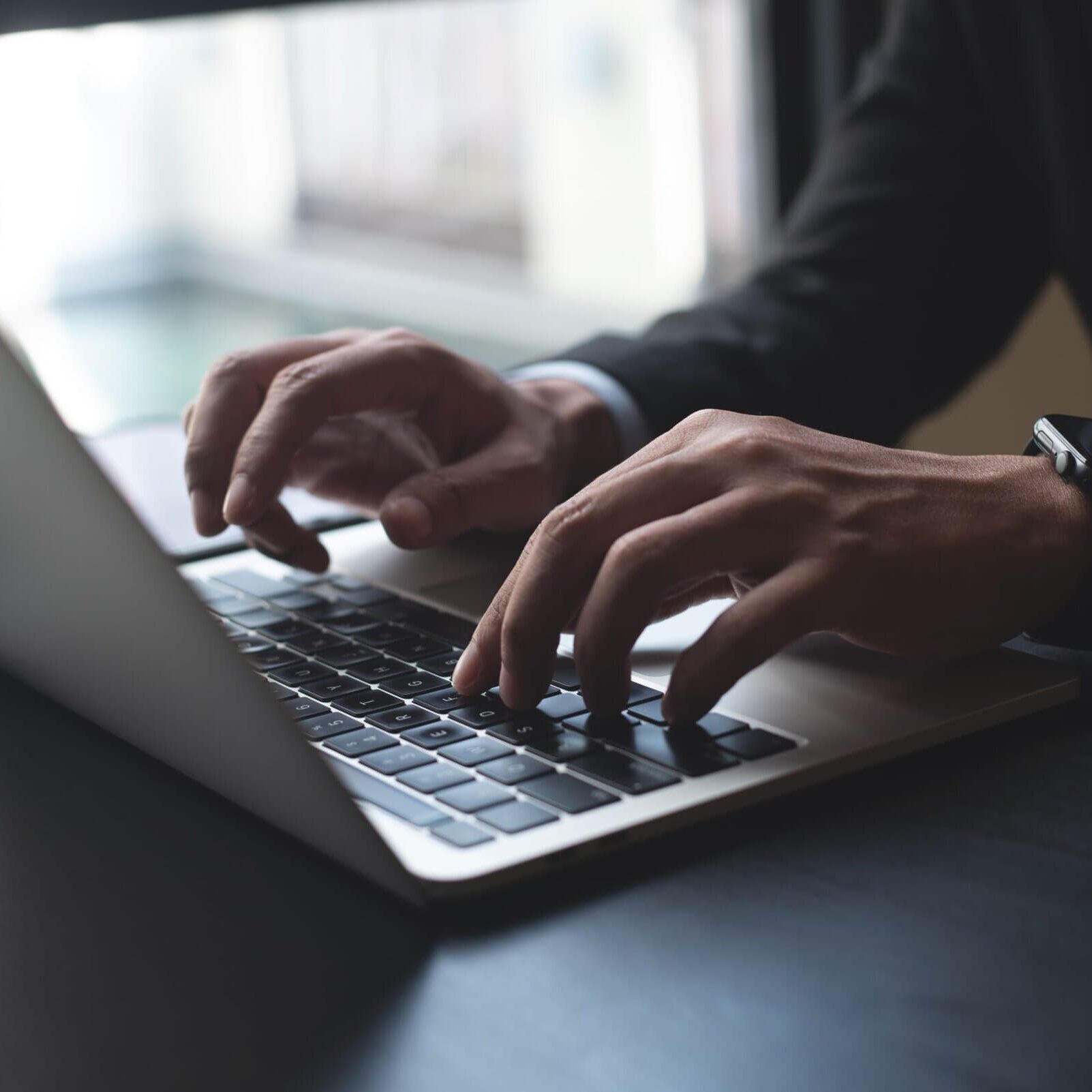 Closeup,Of,Businessman,Hand,Typing,On,Laptop,Computer,At,Office. business professional with hands on a macbook keyboard