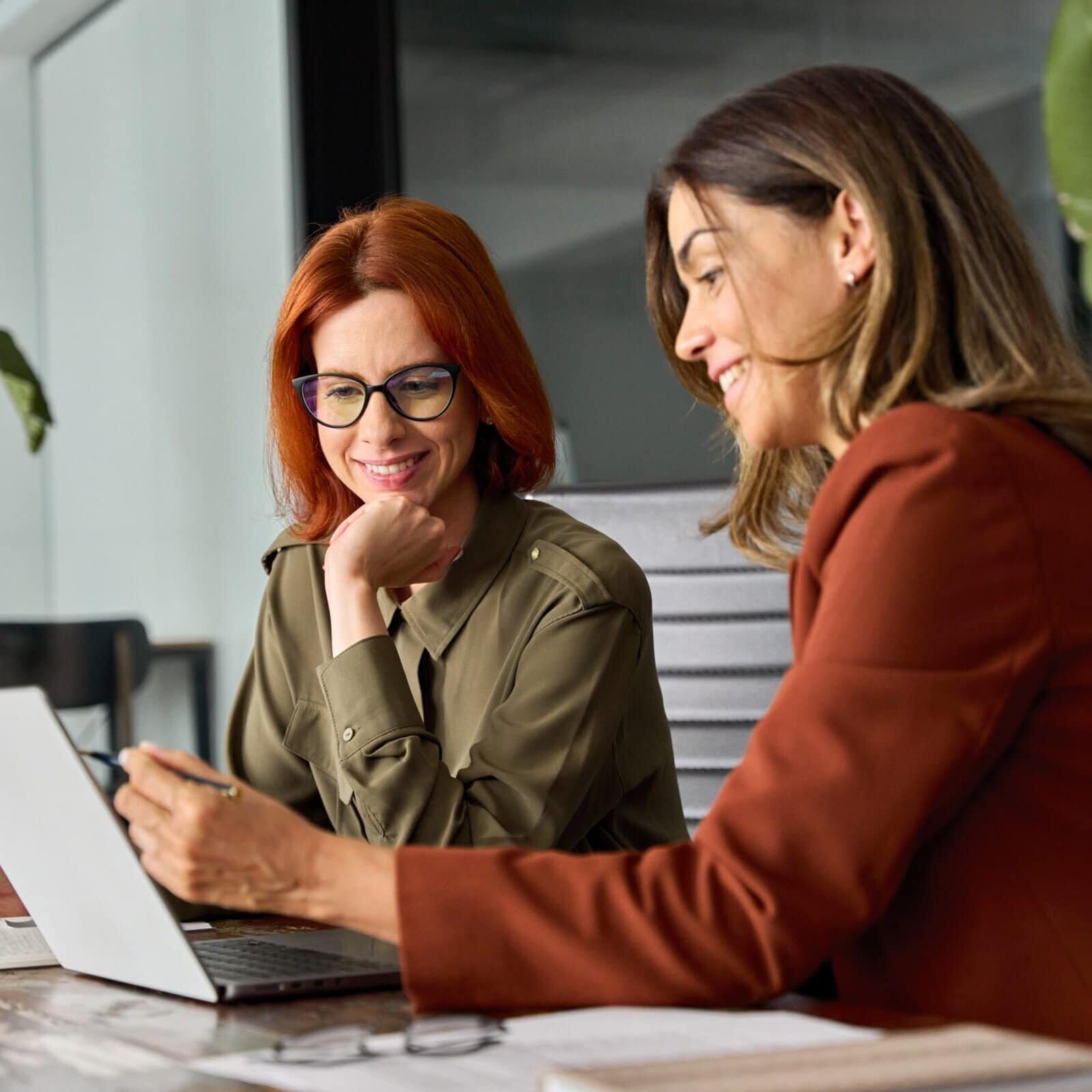 Two,Happy,Busy,Female,Employees,Working,Together,Using,Computer,Planning Two woman review the BDS information in an office setting on a laptop